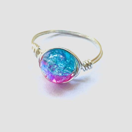 Silver wire ring with an iridescent hot pink and turquoise bead in the centre.
