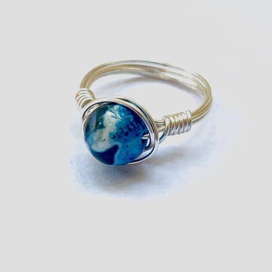 Silver wire ring with a blue-and-white swirl pattern bead.