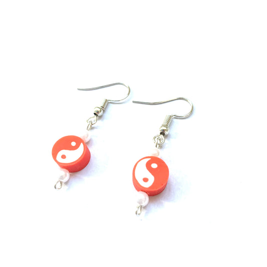 Pair of silver fish hook earrings with a red yin and yang polymer bead and two small faux pearls each.
