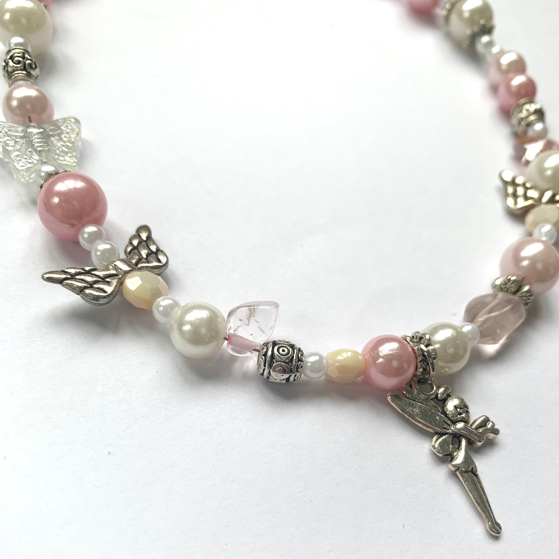Close-up of a beaded Pretty in Pink necklace with an add-on fairy charm by SisBling.