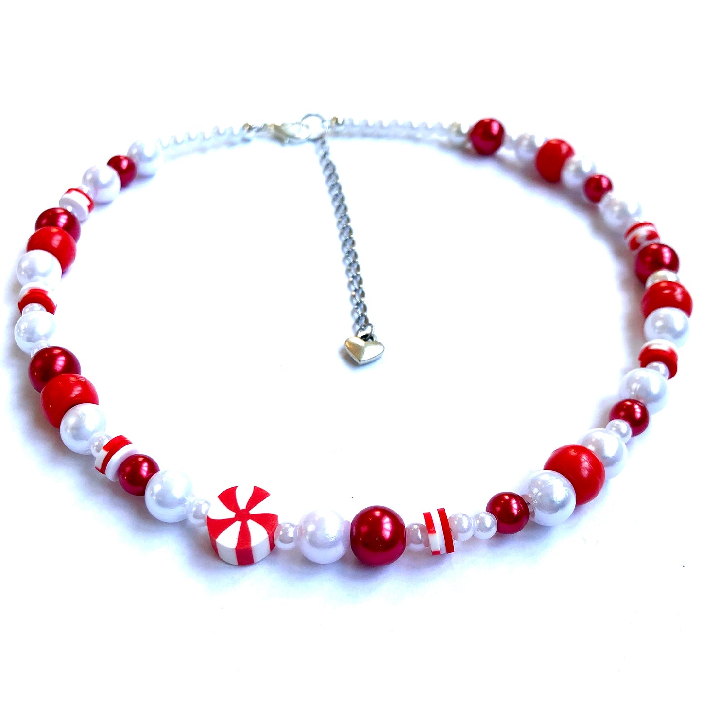 Low-angle shot of a beaded red peppermint necklace with faux white and red pearls and heishi beads.