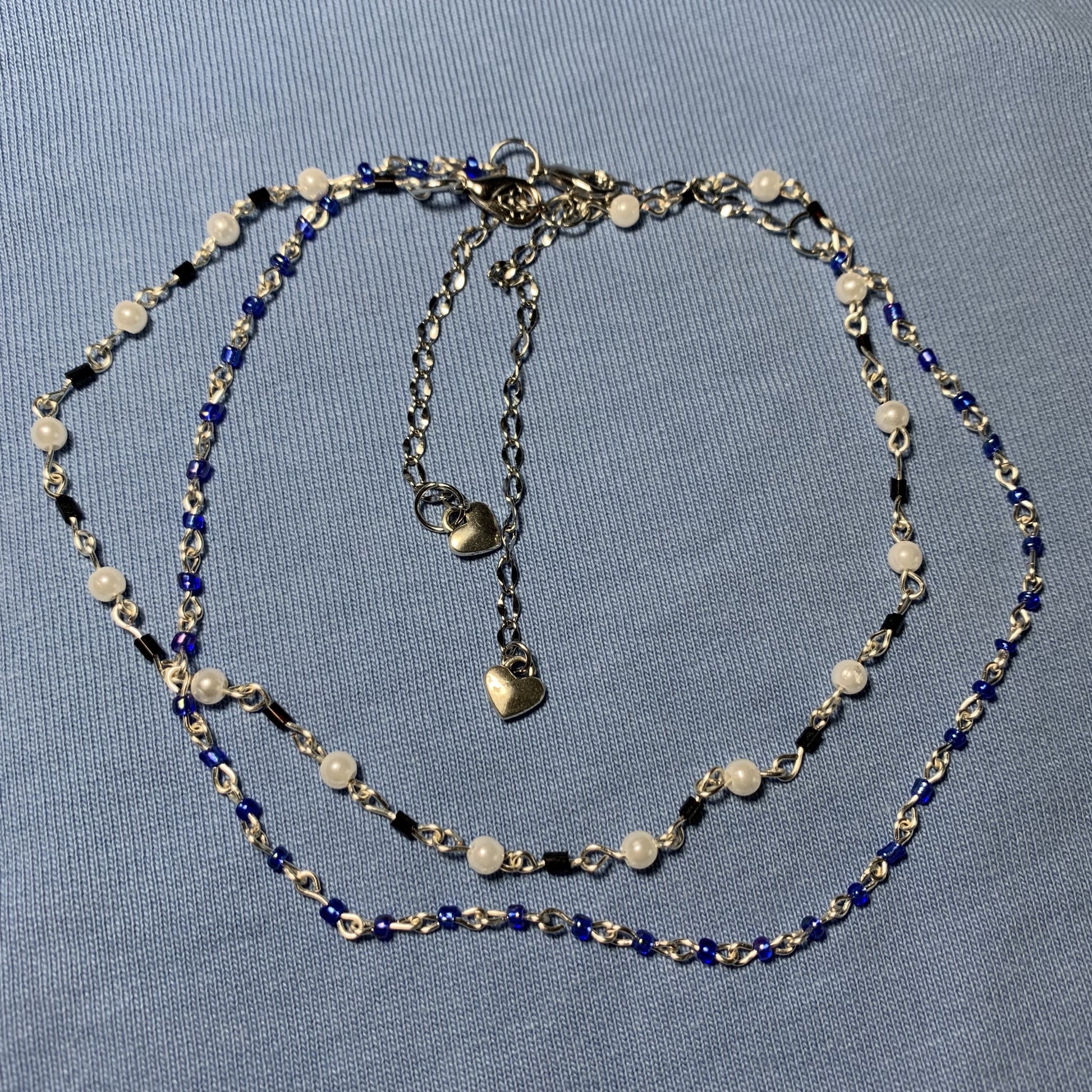 Beaded black and white wire necklace and a beaded blue wire necklace.