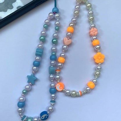 Blue phone charm and orange phone charm each featuring their respective matching coloured beads.