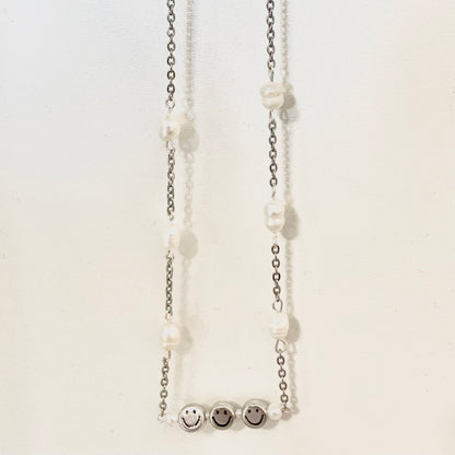 Silver chain necklace connected by freshwater pearls and a wire bar featuring three silver smiley face beads and pearls between each.