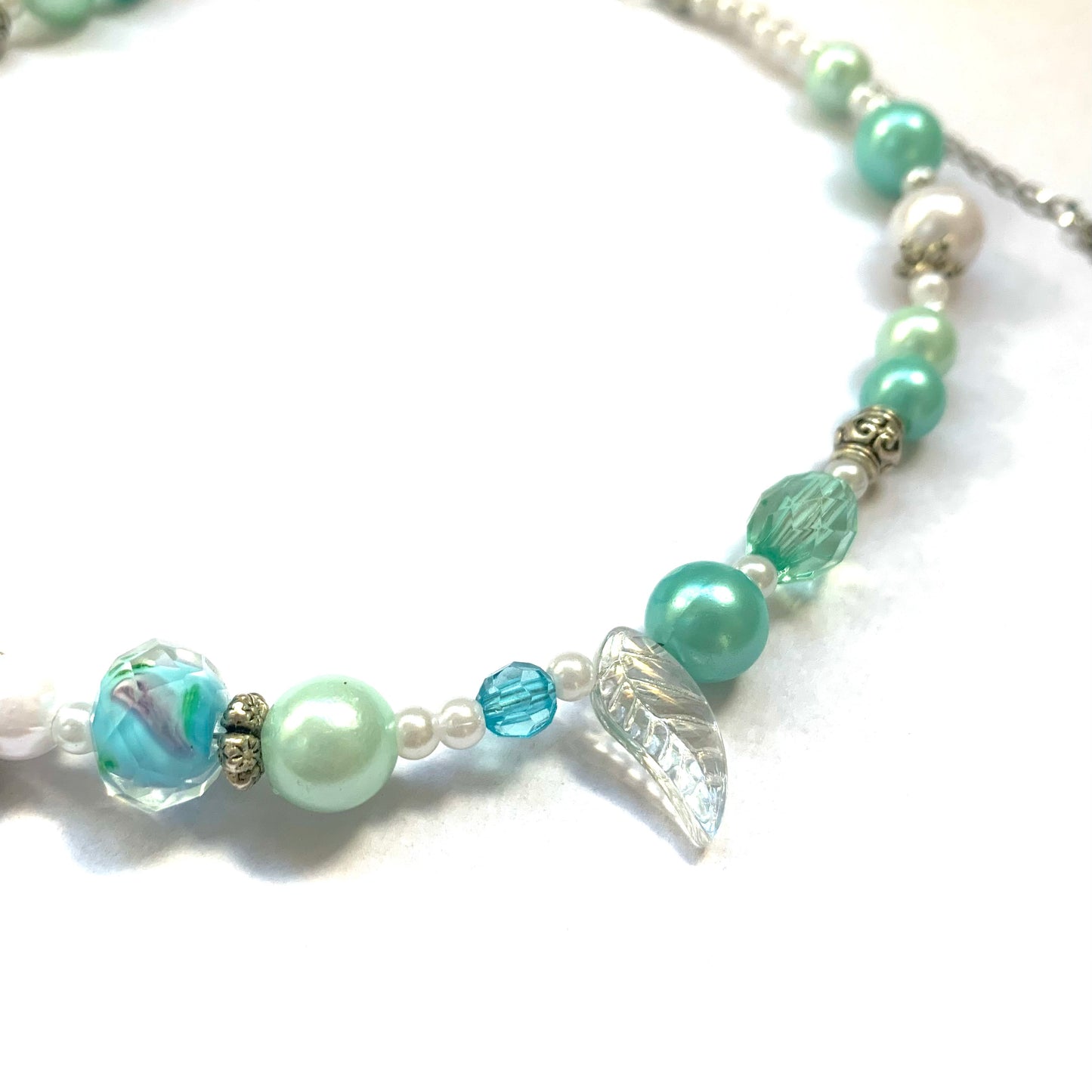 Close-up of turquoise and white glass bead necklace.