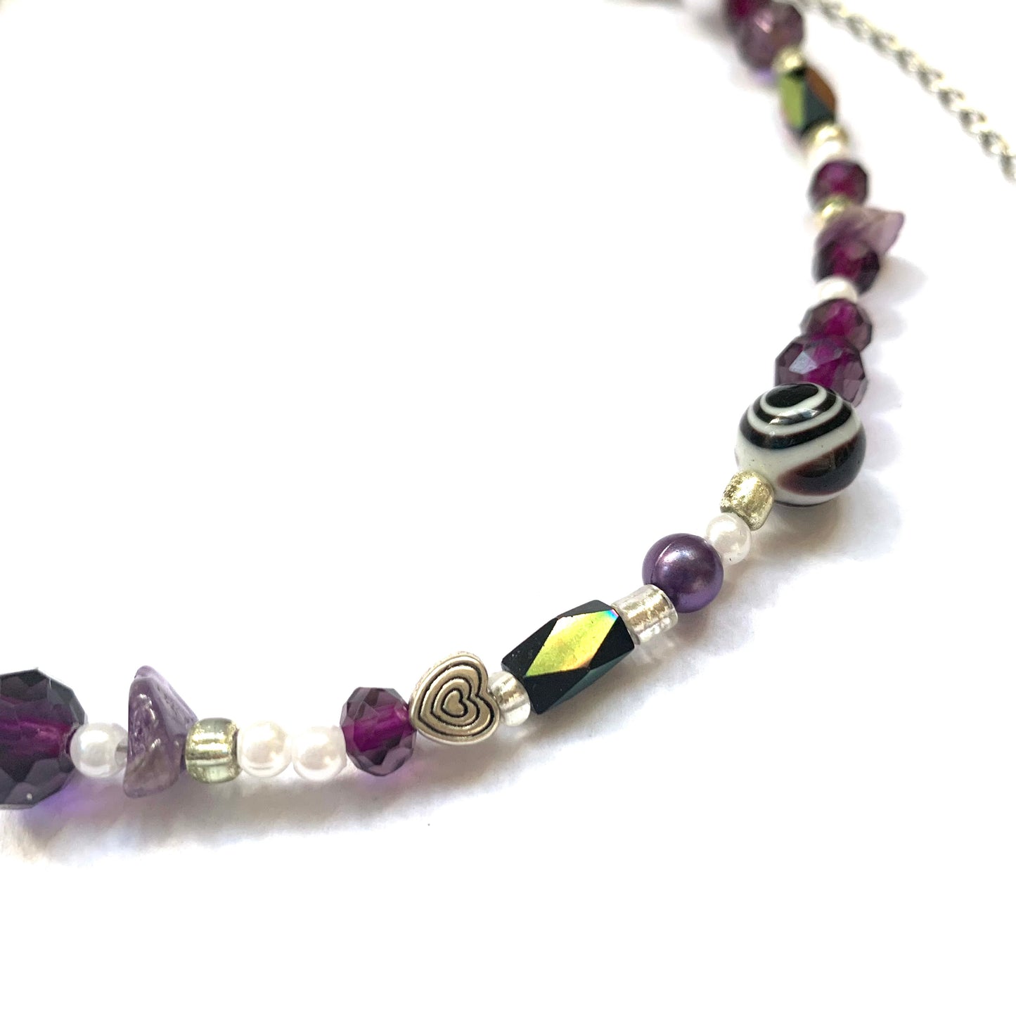 Close-up of an iridescent deep purple and black glass bead necklace.