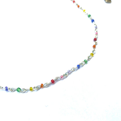 Close-up of a beaded rainbow seed bead wire necklace.