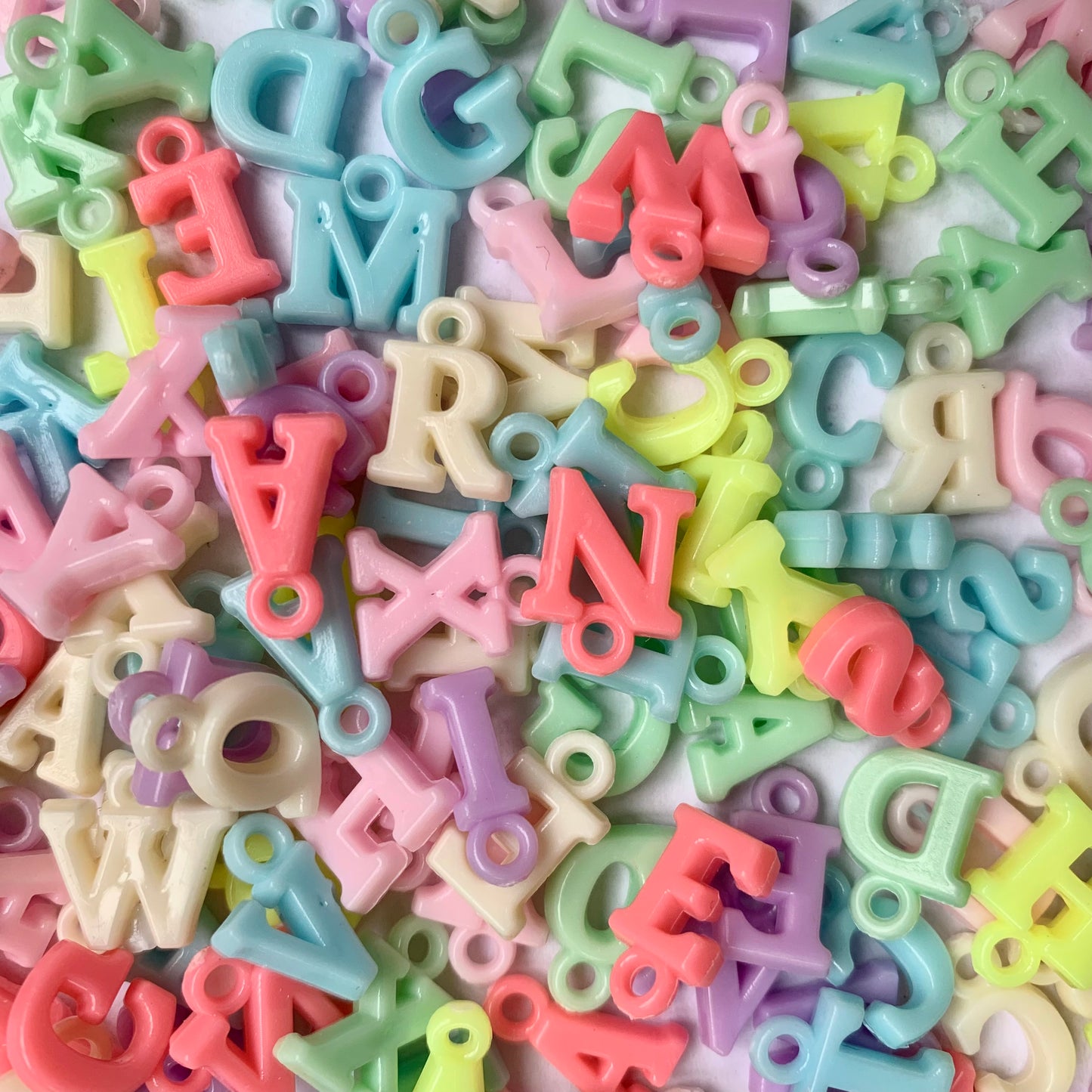 Assorted pastel-coloured letter charms.