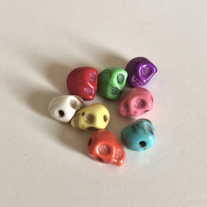 Assorted skull beads in red, white, yellow, orange, green, purple, pink, and blue.