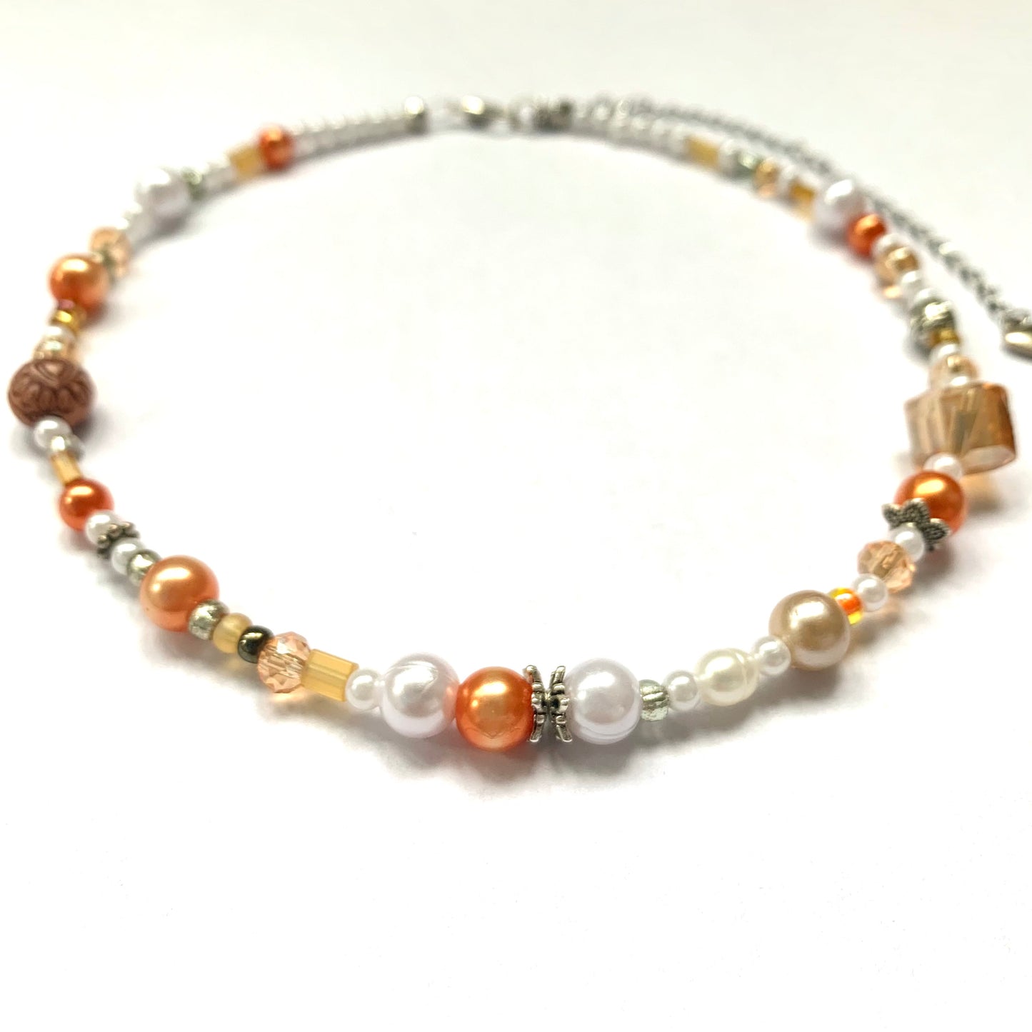 Close-up of an orange and white glass bead necklace.