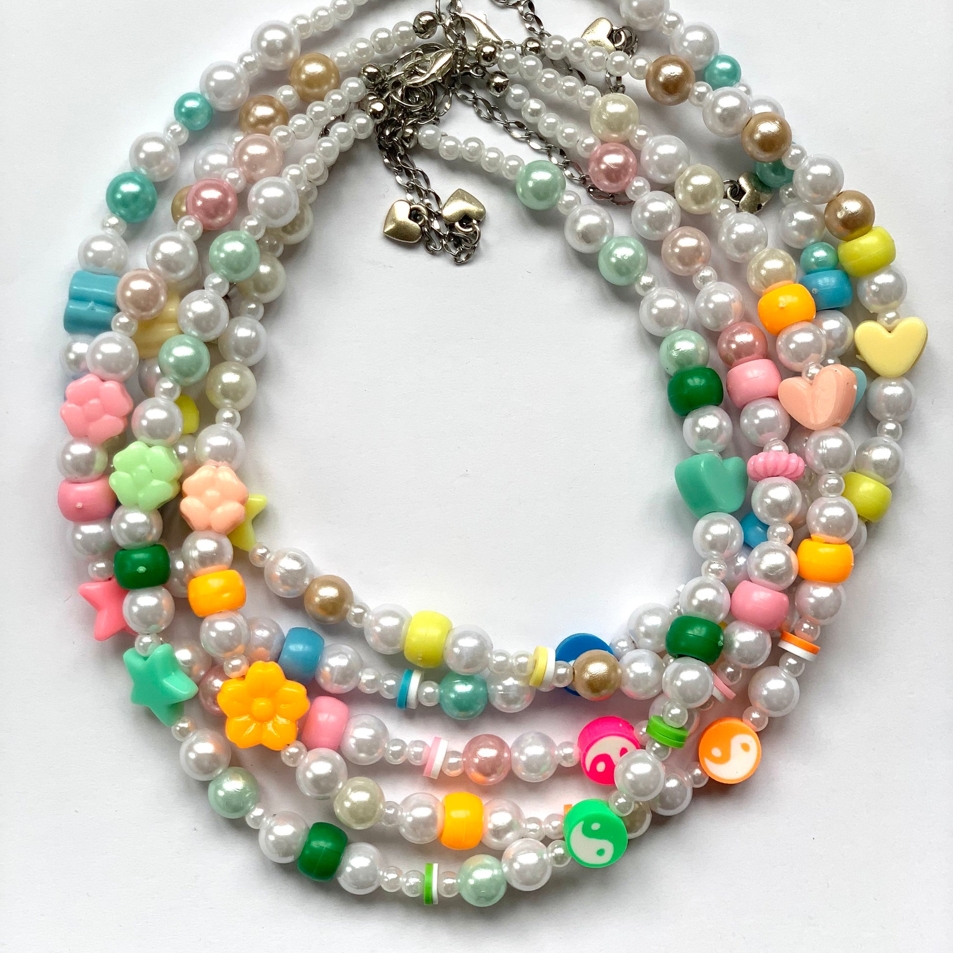 Pink, orange, yellow, green, and blue beaded yin and yang necklaces.