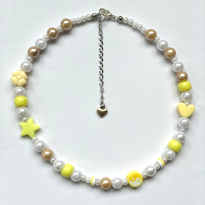 Beaded yellow yin and yang necklace with faux white and beige pearls.